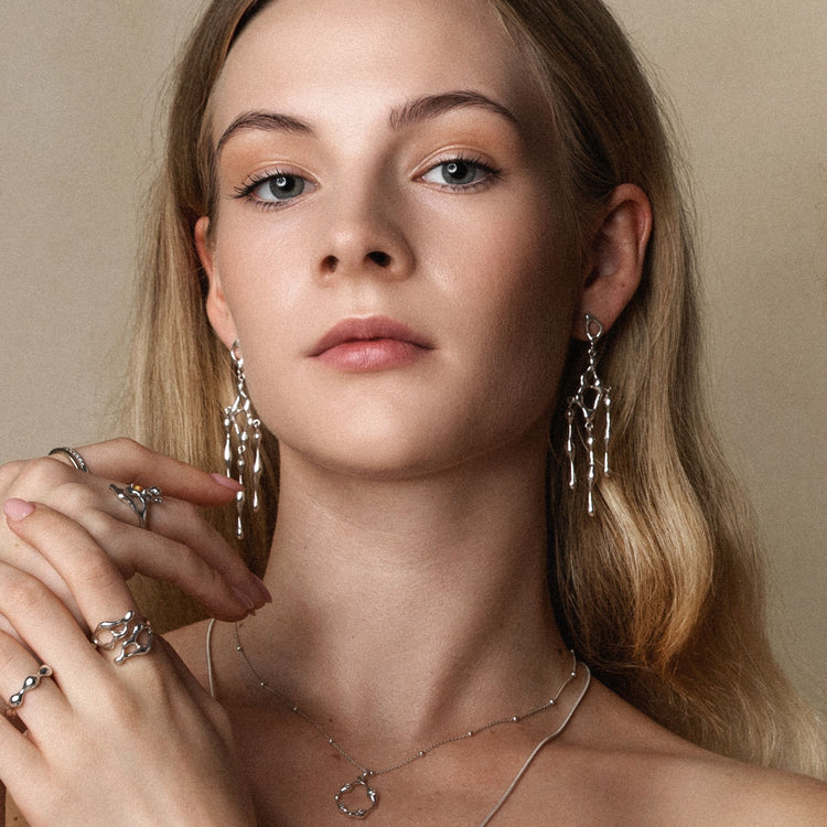 Woman wearing JYOCO Falling Flow silver earrings — artisan designer jewellery