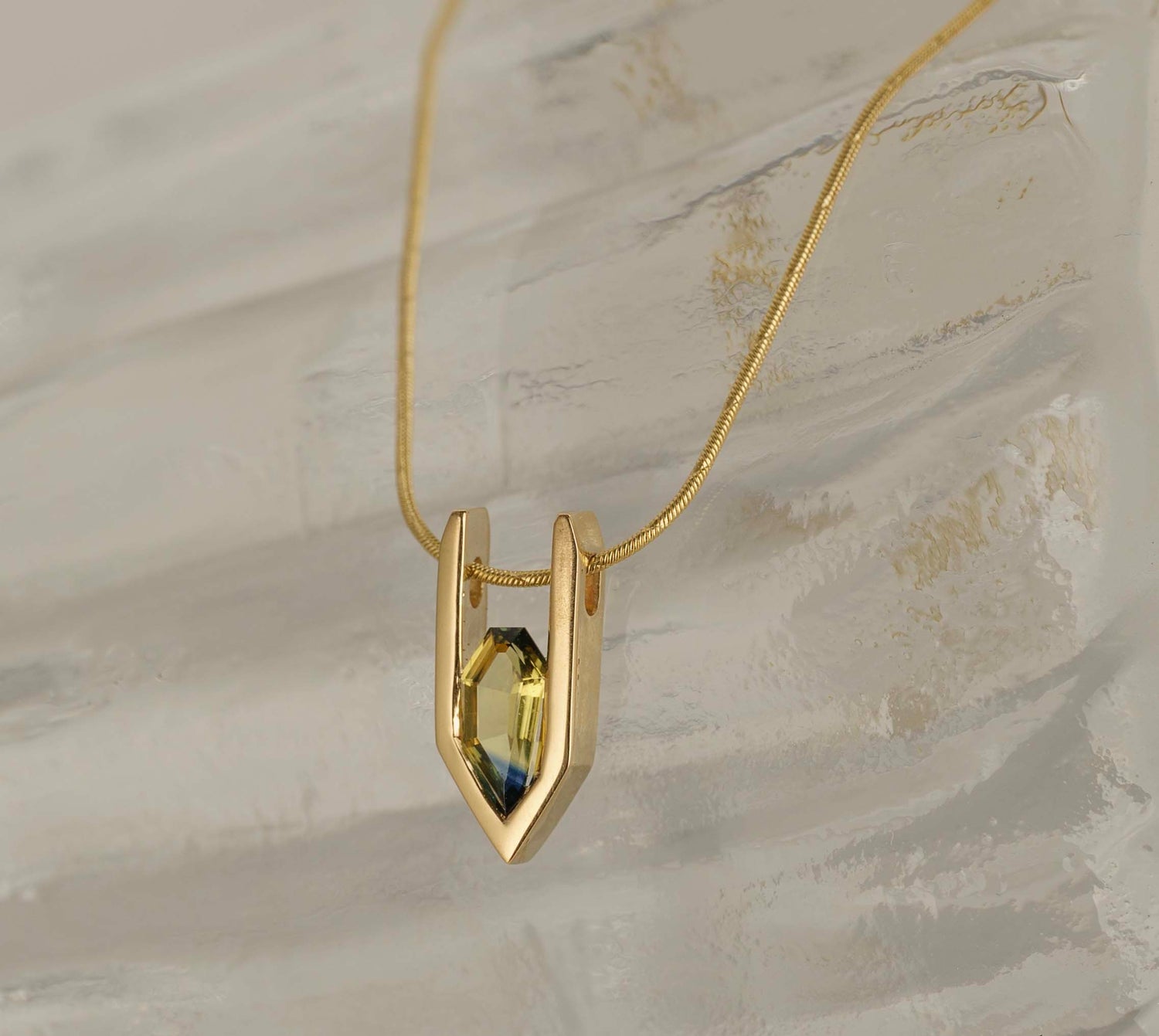 Bespoke gold pendant necklace featuring a natural Australian sapphire, handcrafted sculptural jewellery designed by JYOCO Jewellery