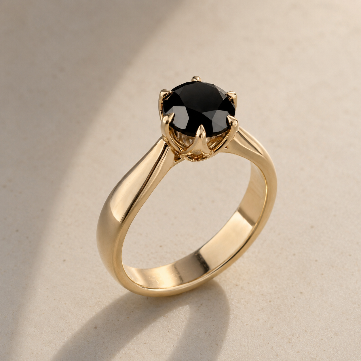 Gold ring with a black gemstone on a beige background