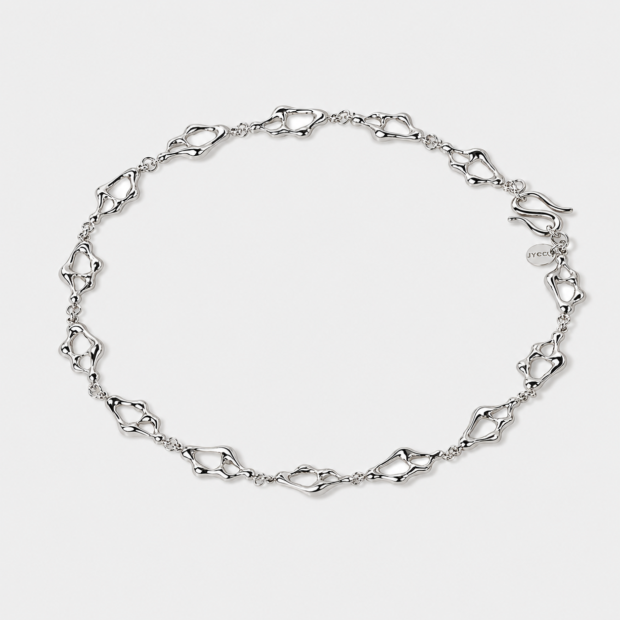Sculptural silver necklace with organic openwork links arranged in a flowing circular composition