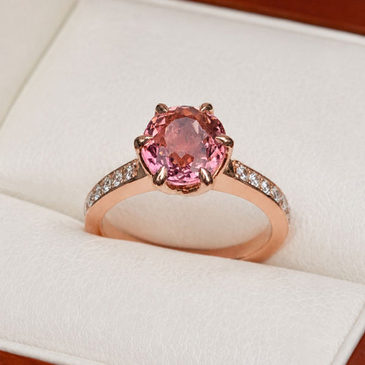Rose gold ring with a pink gemstone in a tpremium beige and wood box