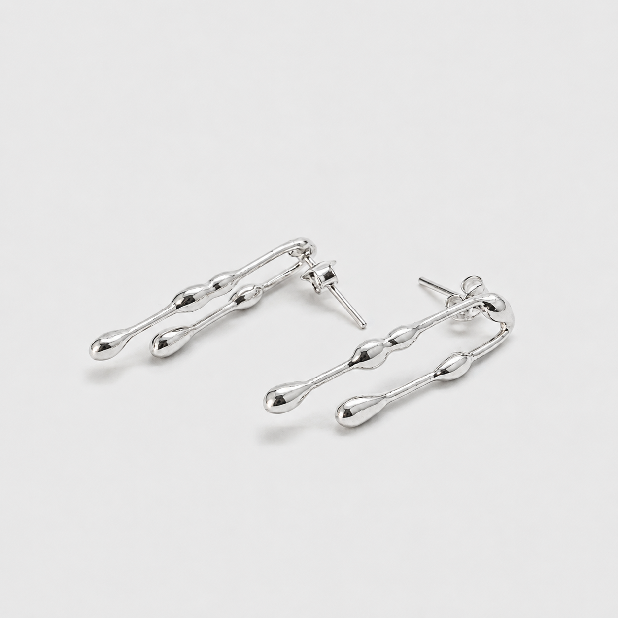 Pair of silver earrings on a light gray background