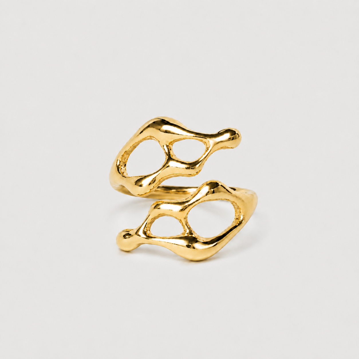 Gold ring with a unique, organic design on a light gray background