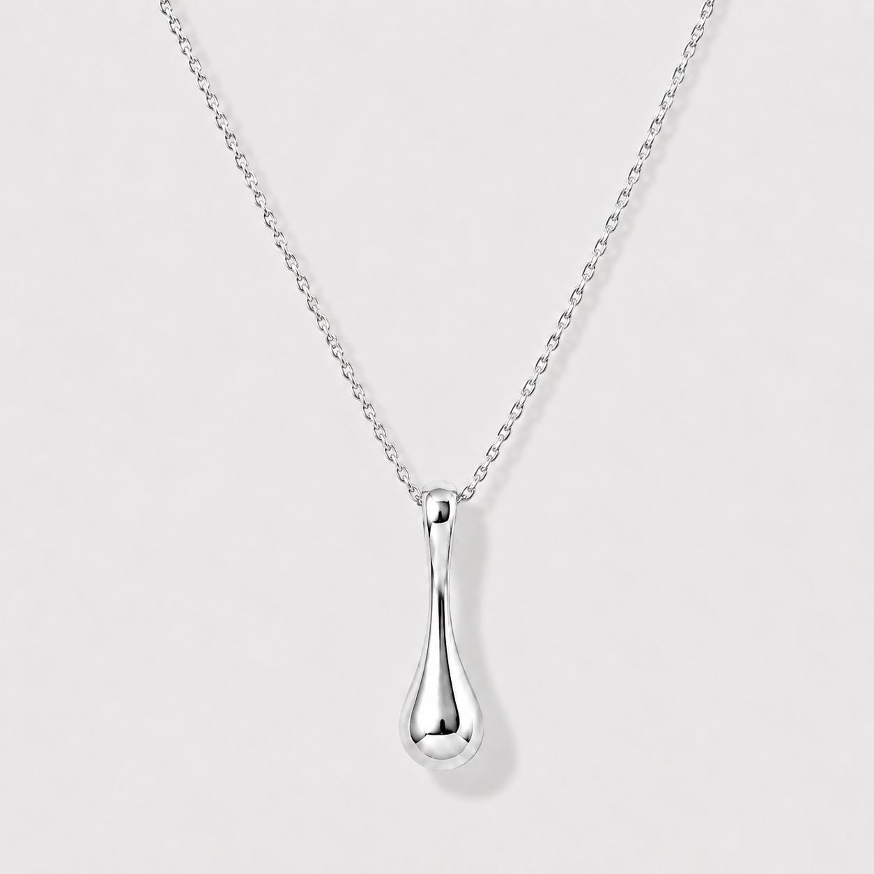 Silver teardrop pendant necklace on a light gray background