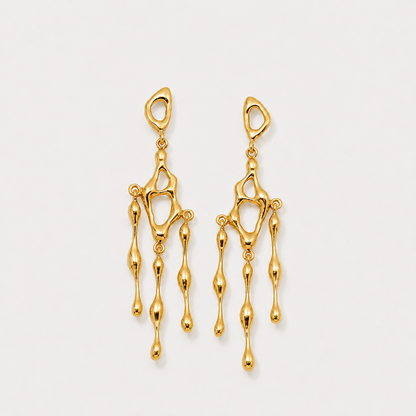 Gold earrings on a light gray background