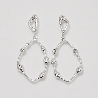 Pair of silver earrings with diamond-like stones on a light gray background