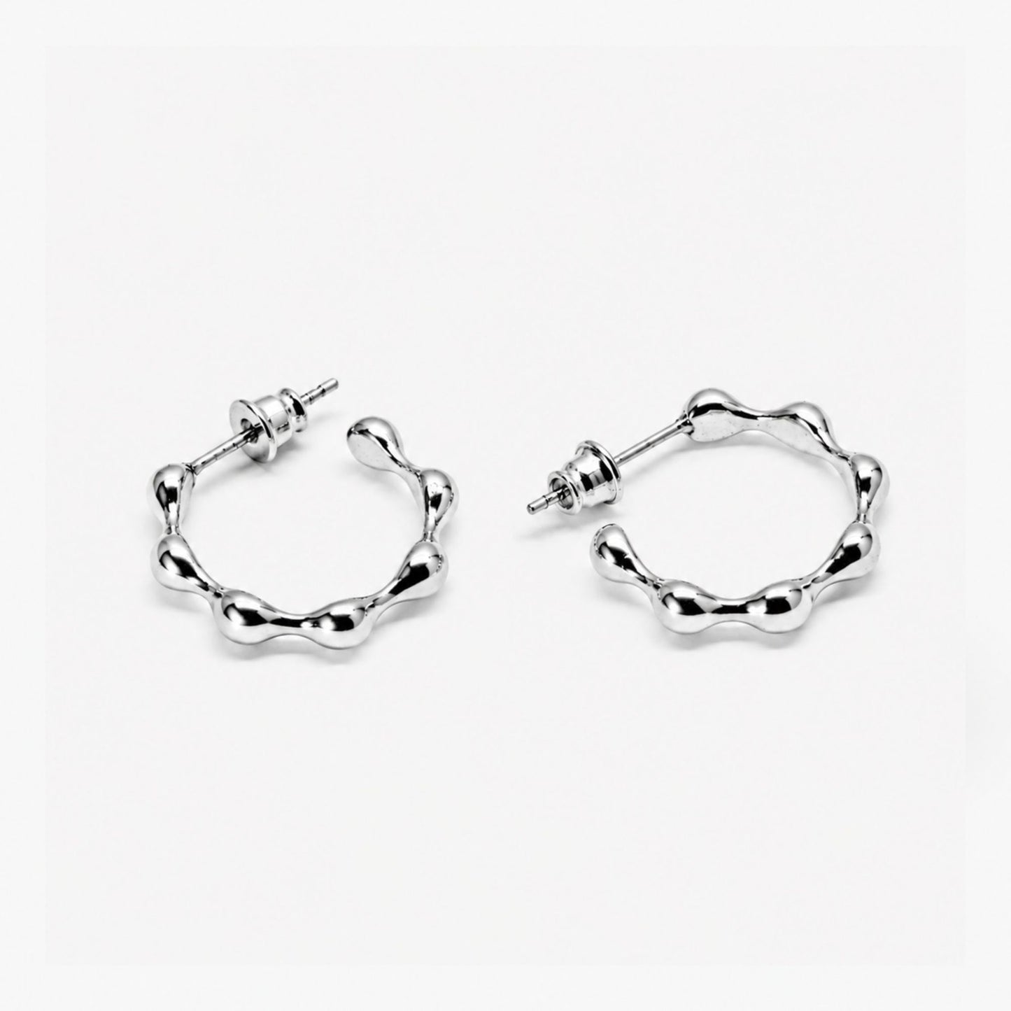 Pair of silver hoop earrings on a white background