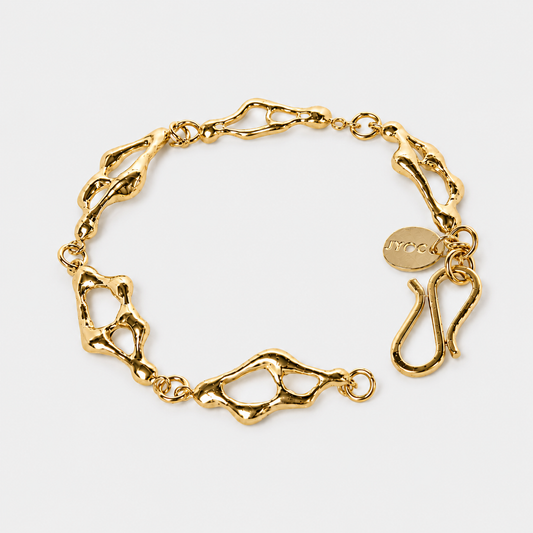 Gold chain bracelet on a light gray background