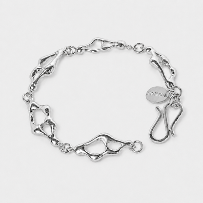 Silver bracelet with a textured design on a light gray background