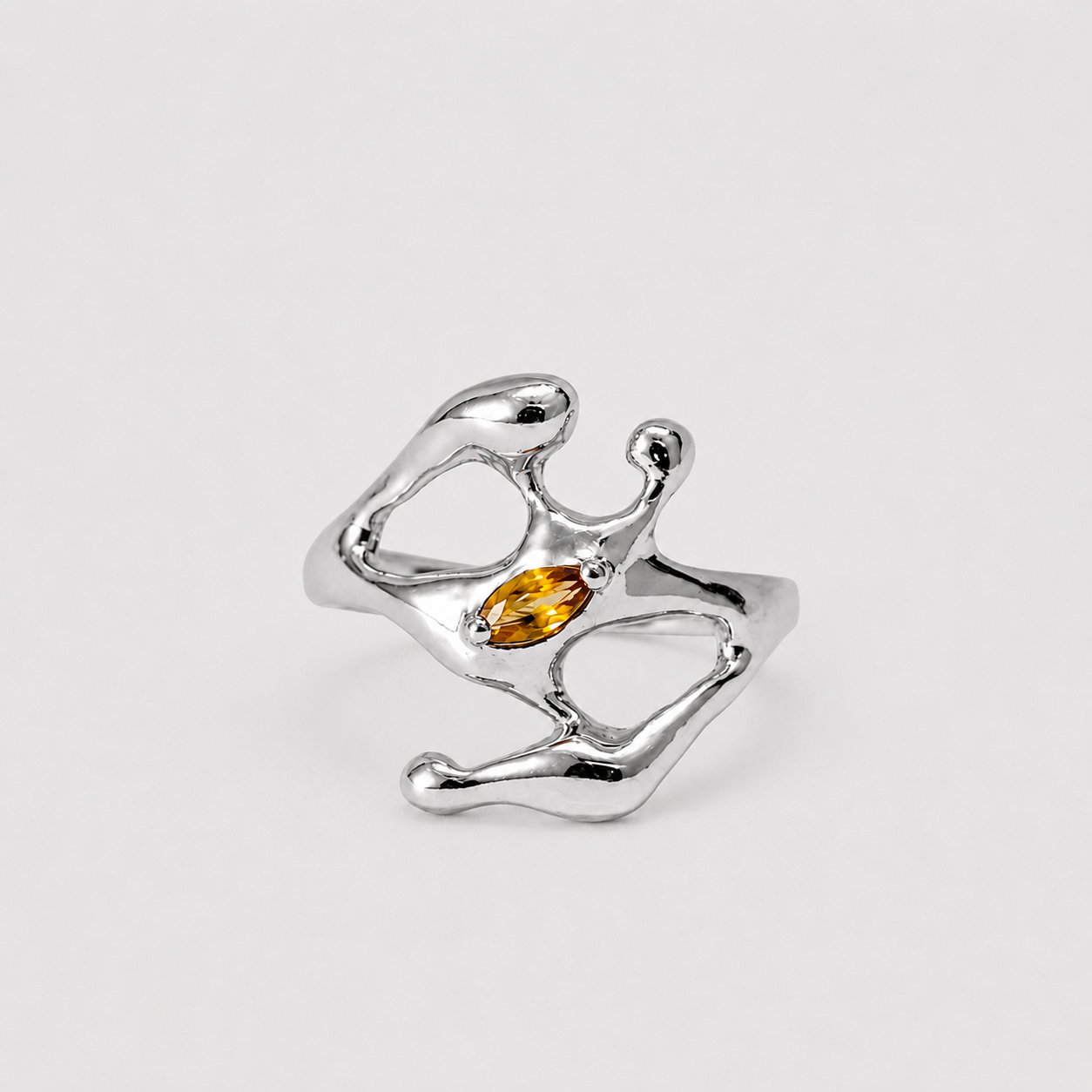 Silver ring with a central amber stone on a light gray background