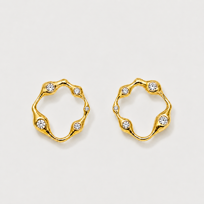 Gold hoop earrings with embedded crystals on a light gray background
