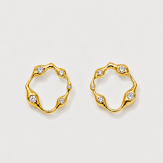 Gold hoop earrings with embedded crystals on a light gray background