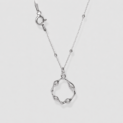 Silver necklace with a unique pendant on a light gray background